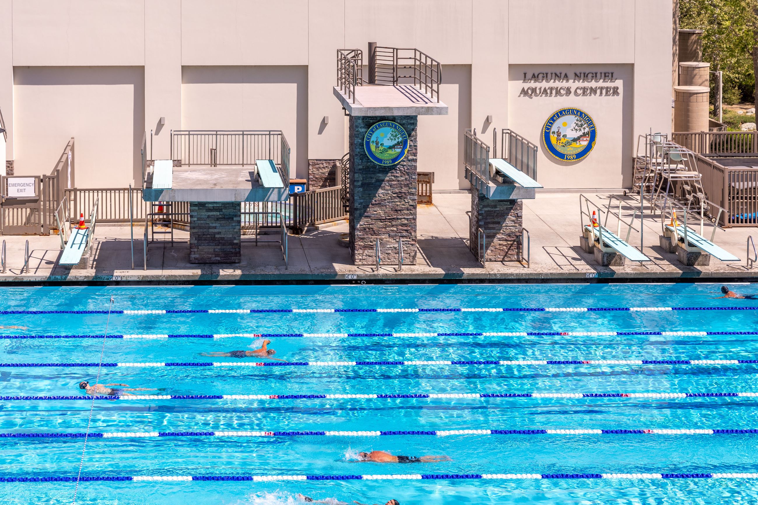 Lap swimmers in outdoor pool with diving boards at Laguna Niguel Aquatics Center.